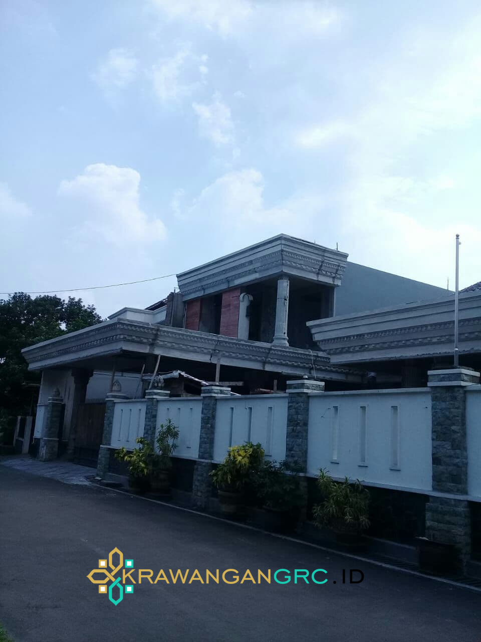 Rumah dengan lisplang GRC profil berornamen di tepi atap dan atap teras