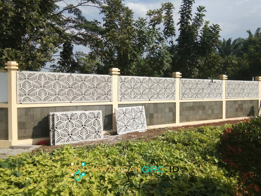 Pagar krawangan GRC motif daun terpasang di atas dinding pembatas, dengan panel yang menunggu dipasang